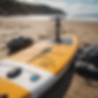 Close-up of essential paddle boarding gear laid out on a beach