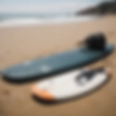 Surfing gear laid out on the sand, including a surfboard and wetsuit