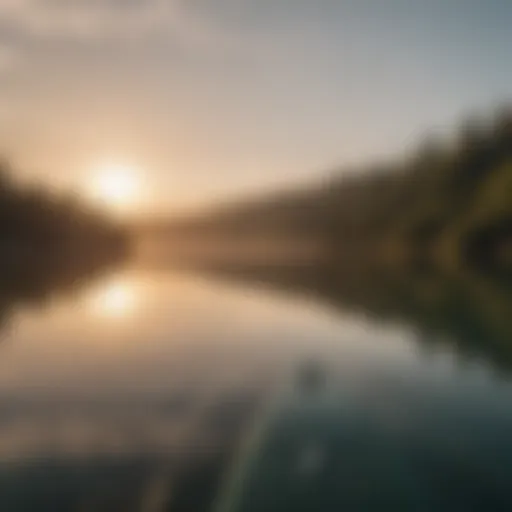 A serene lake with a paddleboarder gliding over the water during sunrise