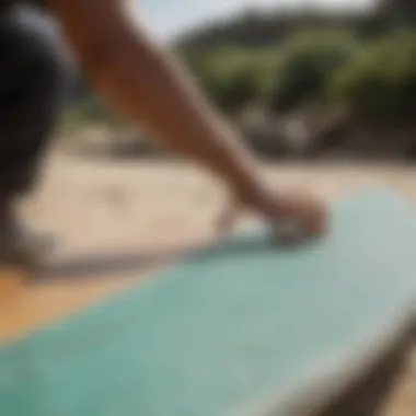 Person carefully lifting griptape off a surfboard