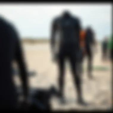 A diverse range of wetsuits displayed on a sandy beach.